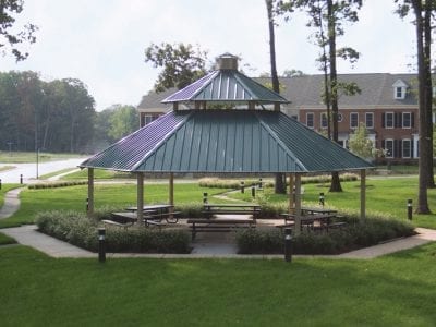 Gazebo with picnic tables in green park.